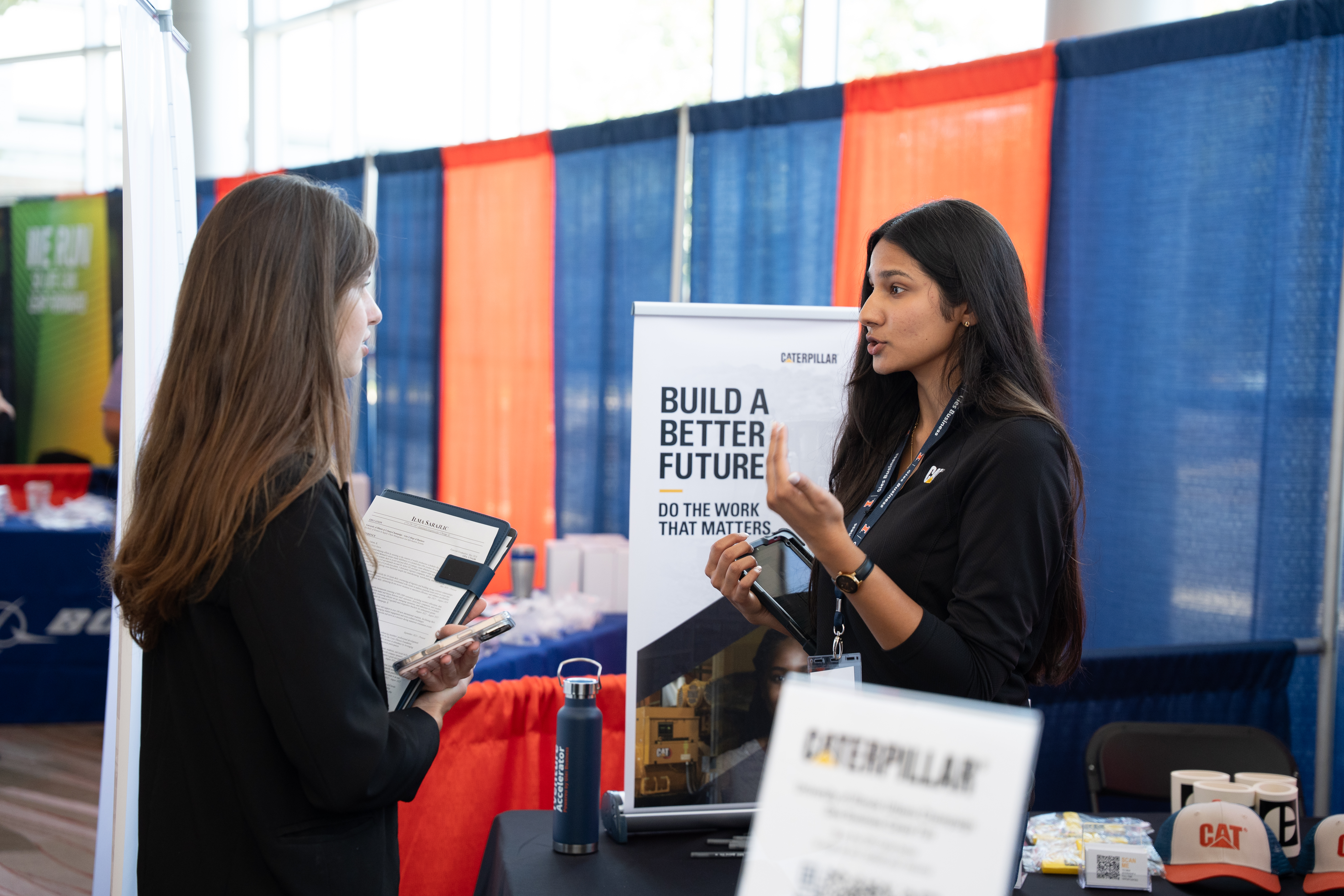 Caterpillar executive standing in front of student in front of student at Job Fair.