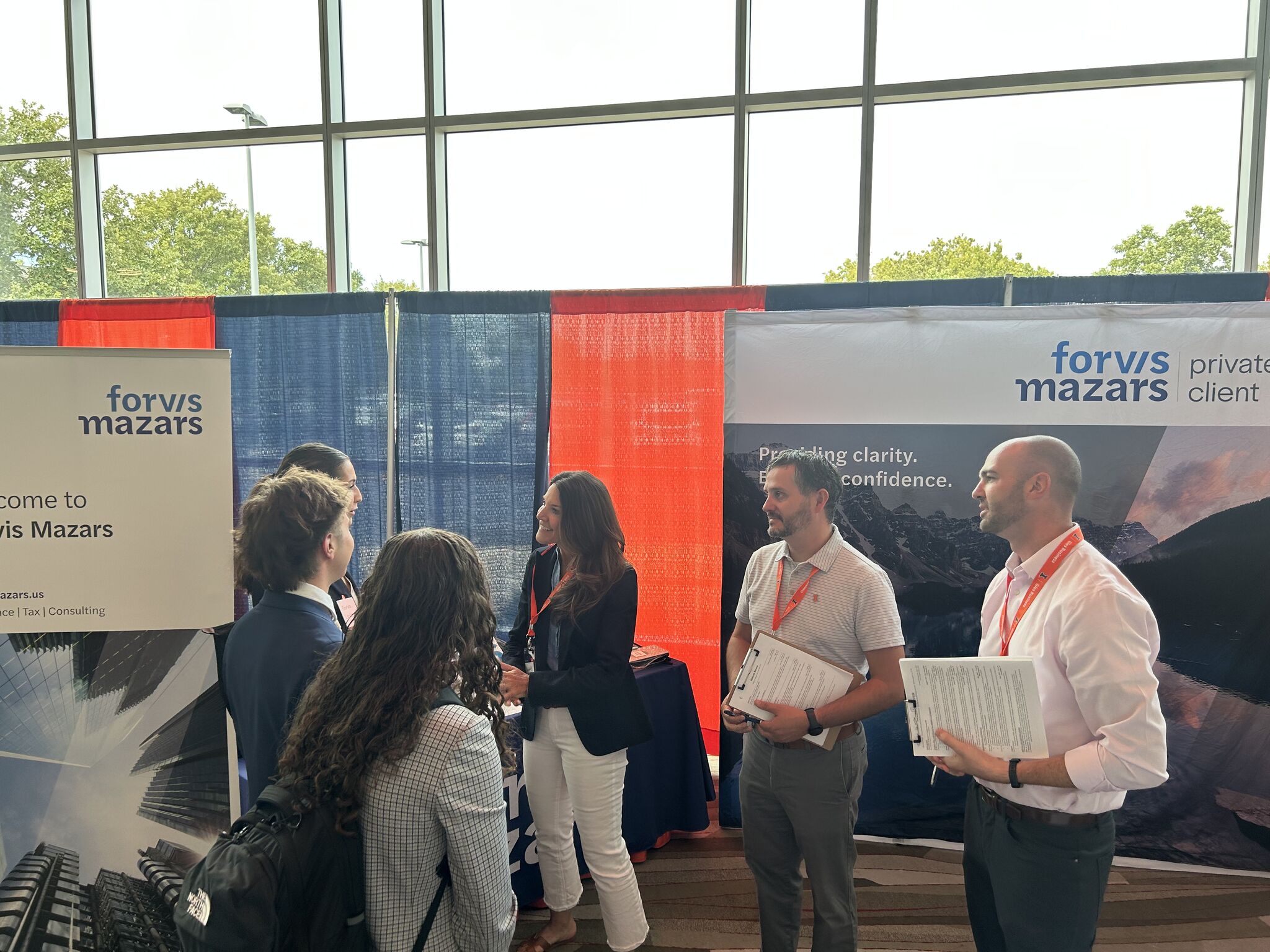 Forvis Mazars executives standing and talking with Gies Students