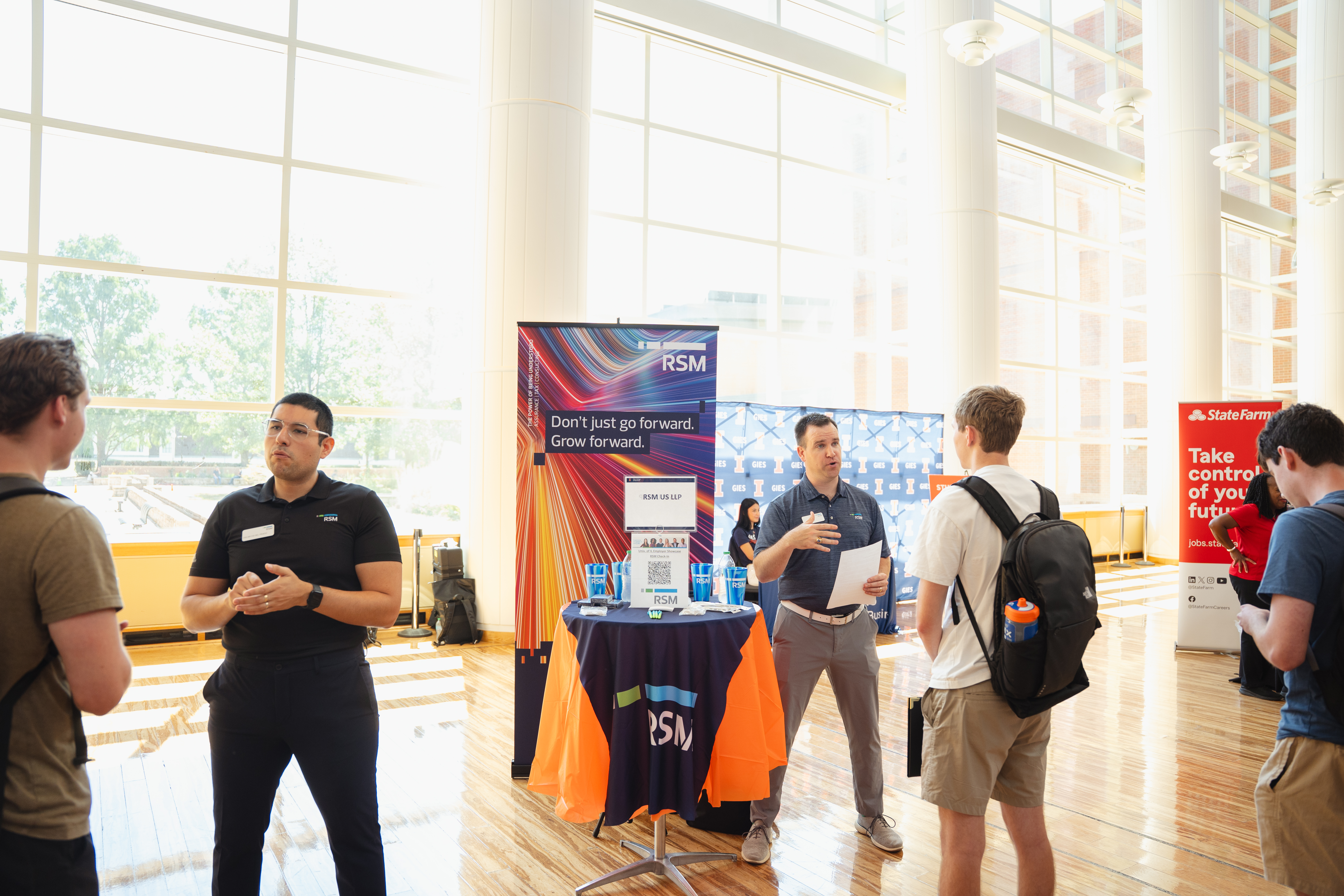 RSM employees talking with students at booth