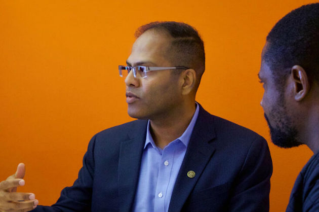 A faculty member speaks while a student listens on