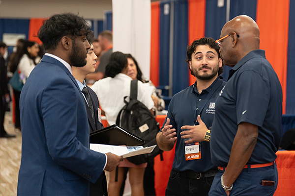Students talking to employers at a career fair Students talking to employers at a career fair