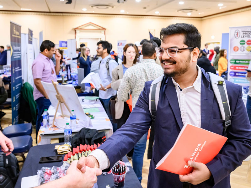 University of Illinois student shaking hands with employer at Career Fair University of Illinois student shaking hands with employer at Career Fair