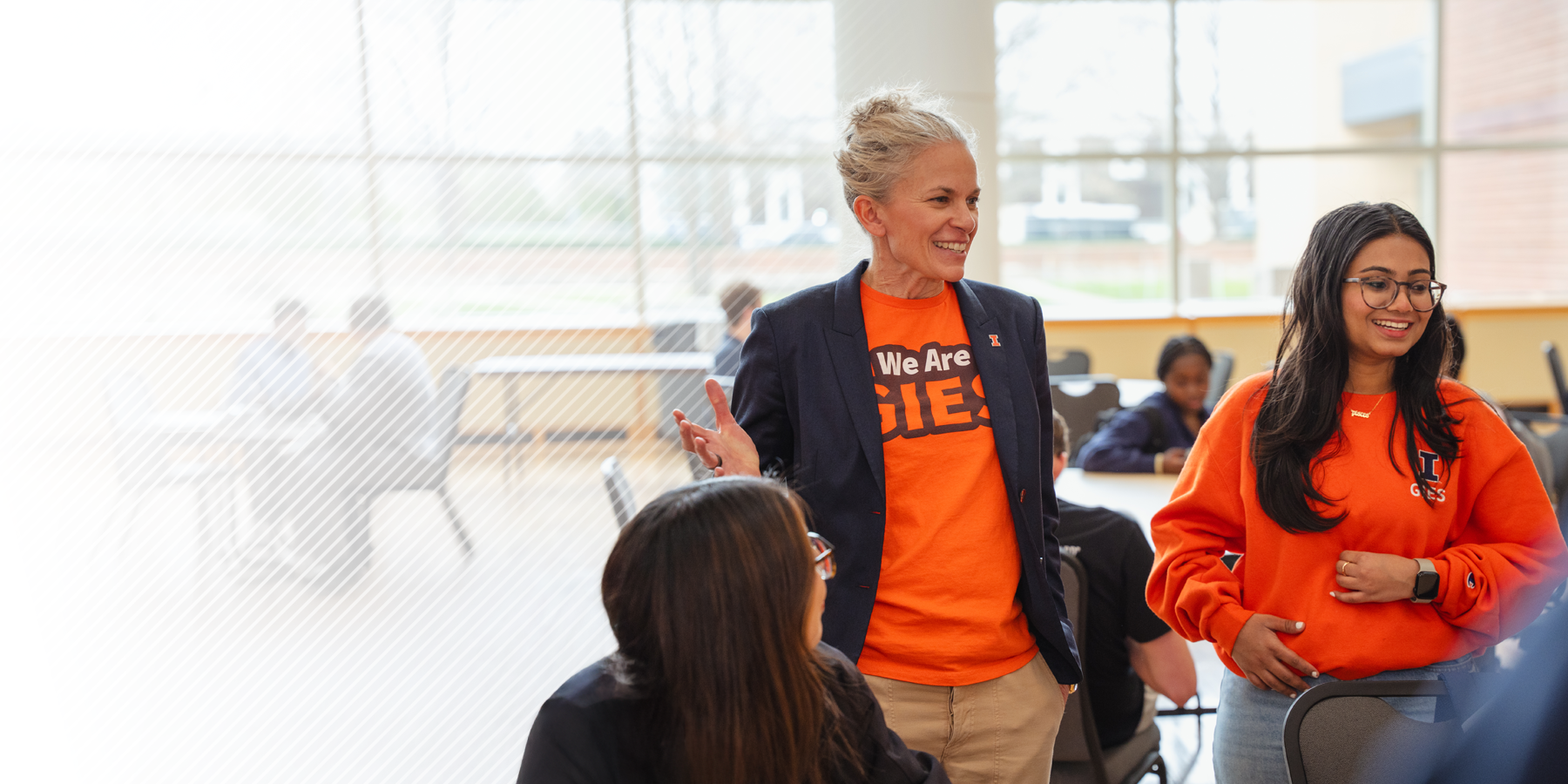 Gies Business Dean Elliott speaking with students in the BIF Atrium