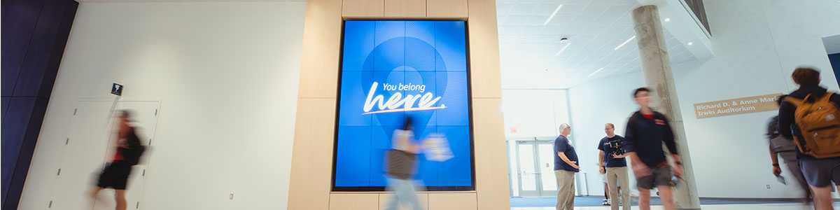 Wymer Hall digital wall with students walking by