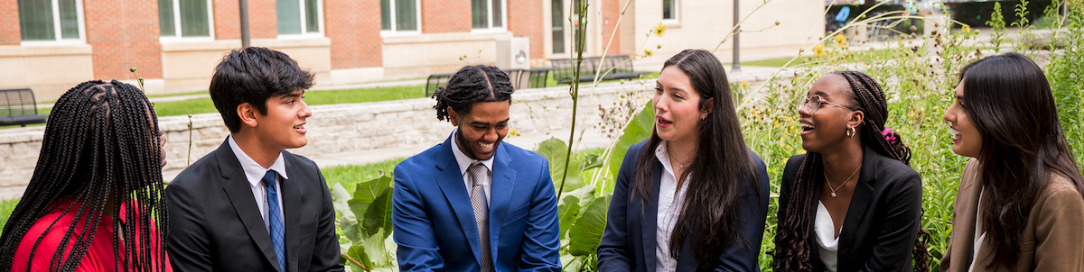 Gies Business students sitting outside talking.