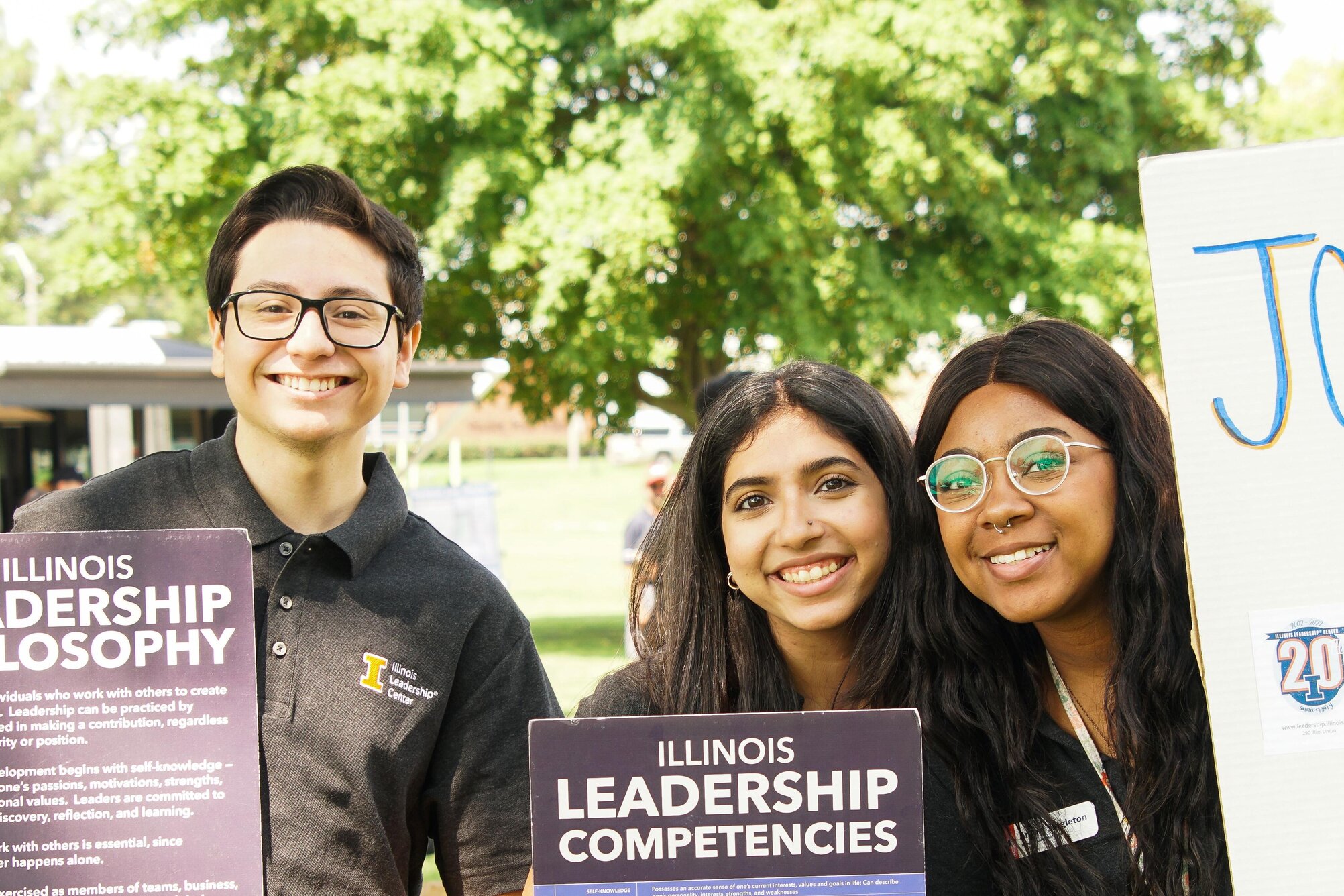 Students holding Illinois Leadership Competencies posters outside.