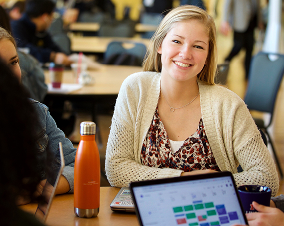 Smiling student at a table with other students