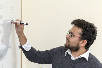 Financial Information Residential Course A professor stands before his class at a whiteboard.