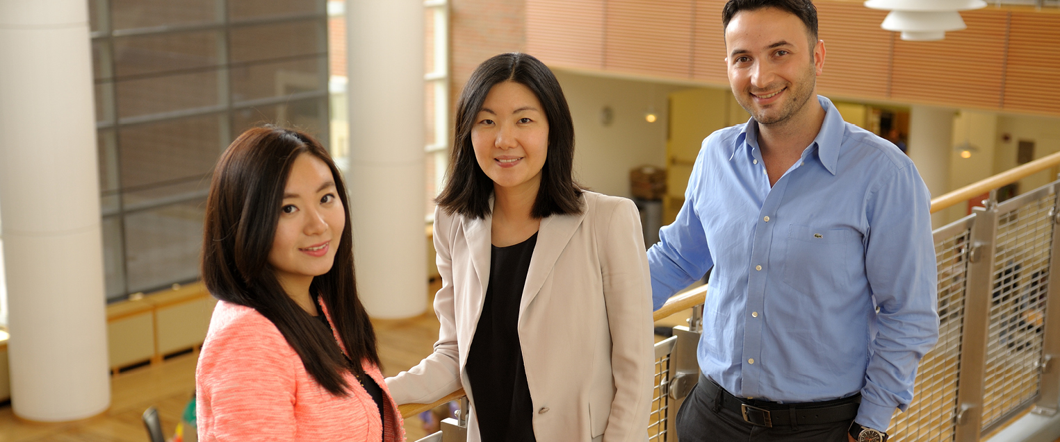 Full Story Photo for BADM PhD Three students leaning on railing in business professional attire